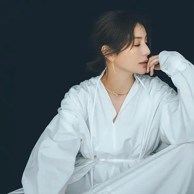 シャツカラーに映えるローズゴールドの強く、つややかな曲線