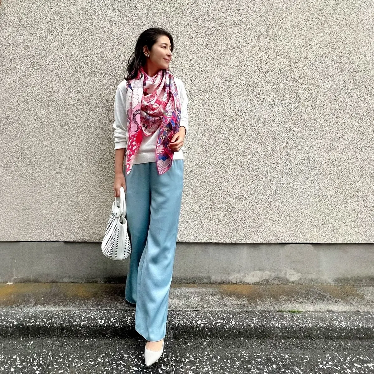 白ニット　ライトブルーのパンツ　白のバッグ　ピンク系柄物ストール　グレーのパンプス