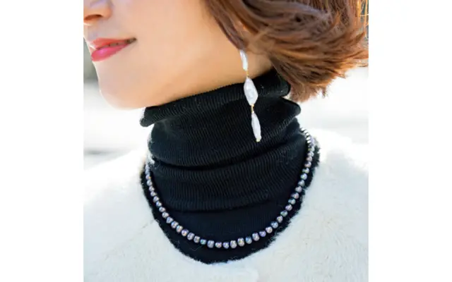 コートの襟に添うベビーパールとバロックパールのピアス。あえて異なる色やサイズが◎。