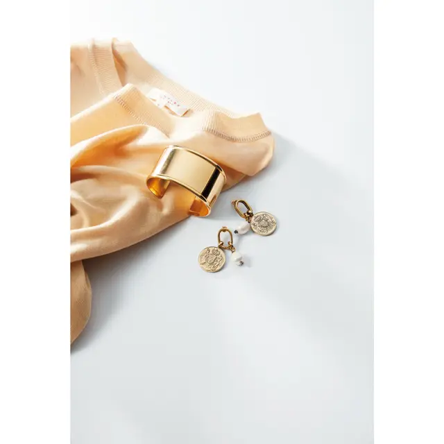 シンプルなクリームベージュのニットをゴールドアクセで華やかに