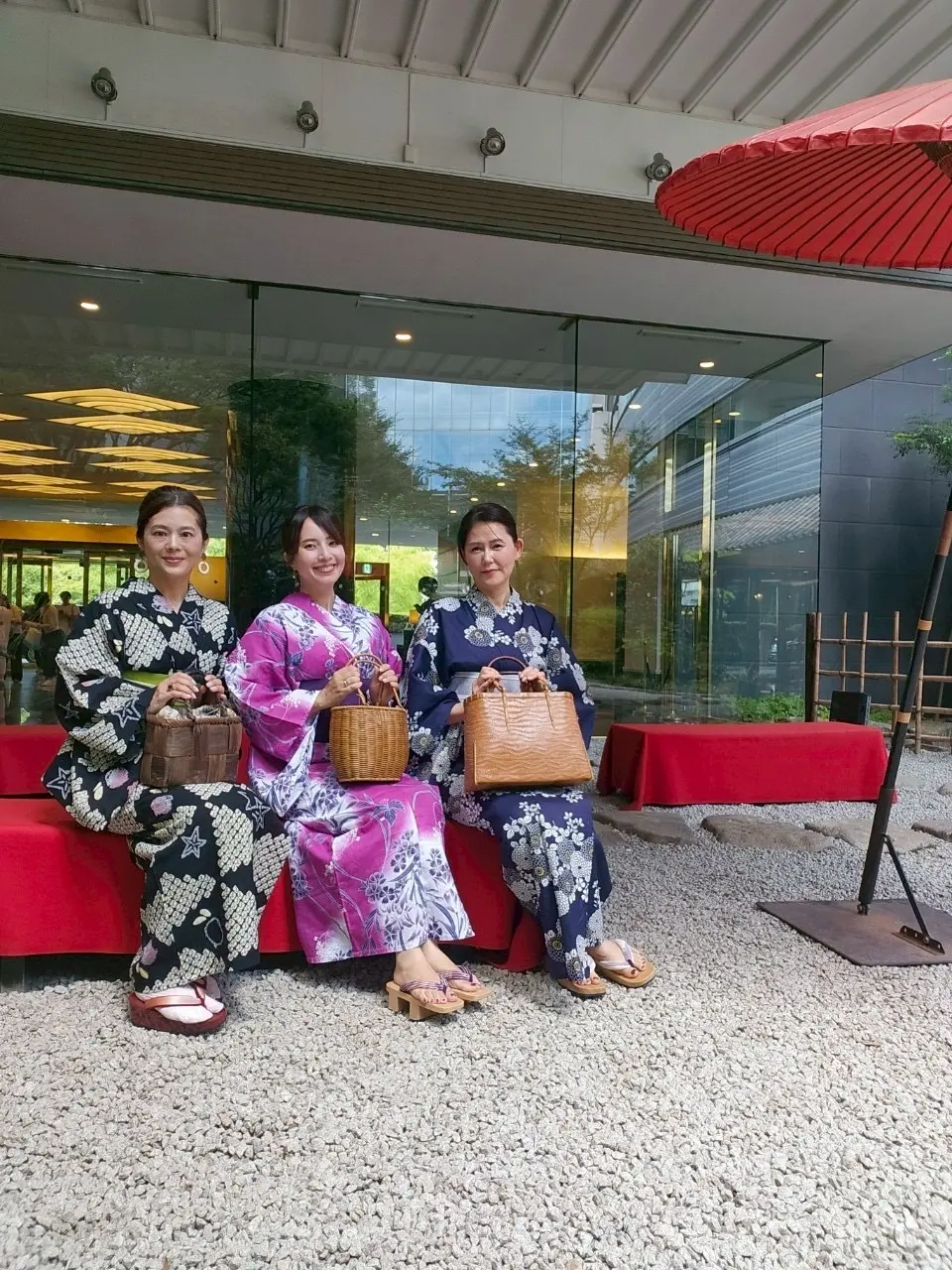 雅叙園の中庭の赤い番傘と3人の浴衣姿の女性。