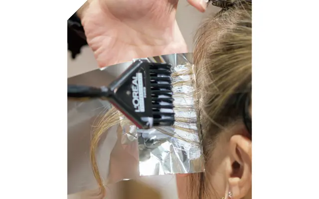 地肌につかないようすじ状の毛束にブリーチ剤を塗布。 白髪とそれ以外の髪へ同時にハイライトを入れて、自然なすじ状カラーにしていく。