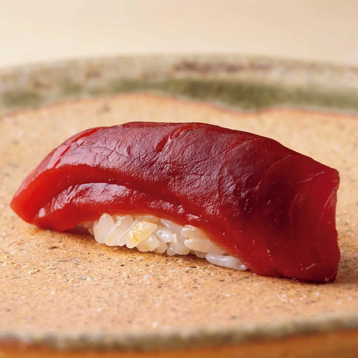 マグロの漬けと薄く切った赤 身を重ねてにぎりに。マグロ は舞鶴産