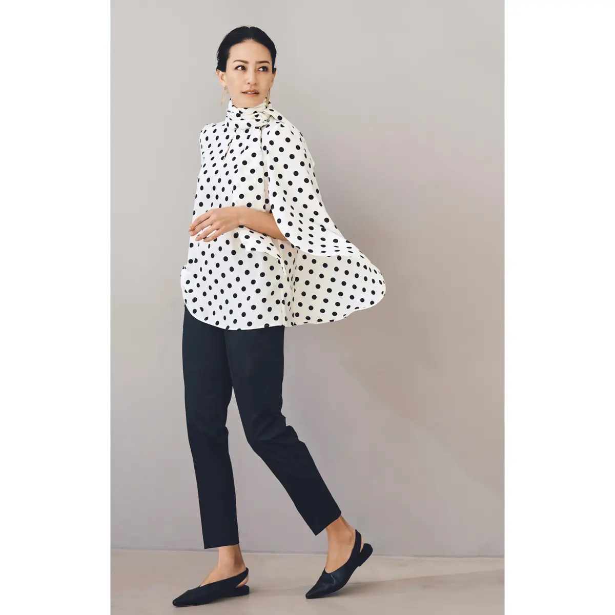 白ベースに黒ドット柄のフレアスリーブブラウスに黒スリムパンツを合わせたコーディネート　モデル・RINA