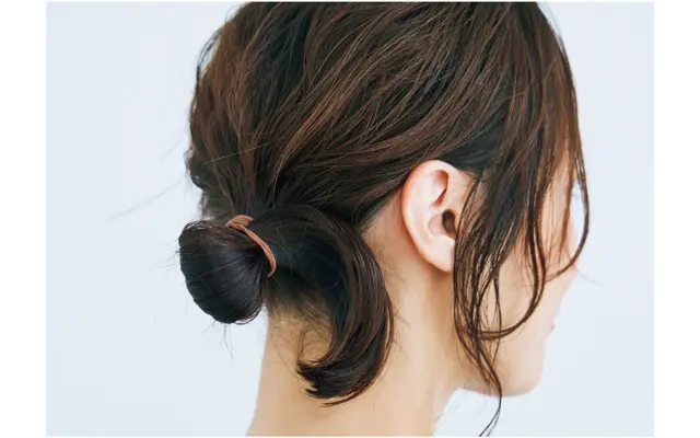 《1》髪全体をラフに巻きサイドでひとつ結び。毛先をゴムに通しきらない輪っか状おだんごに。