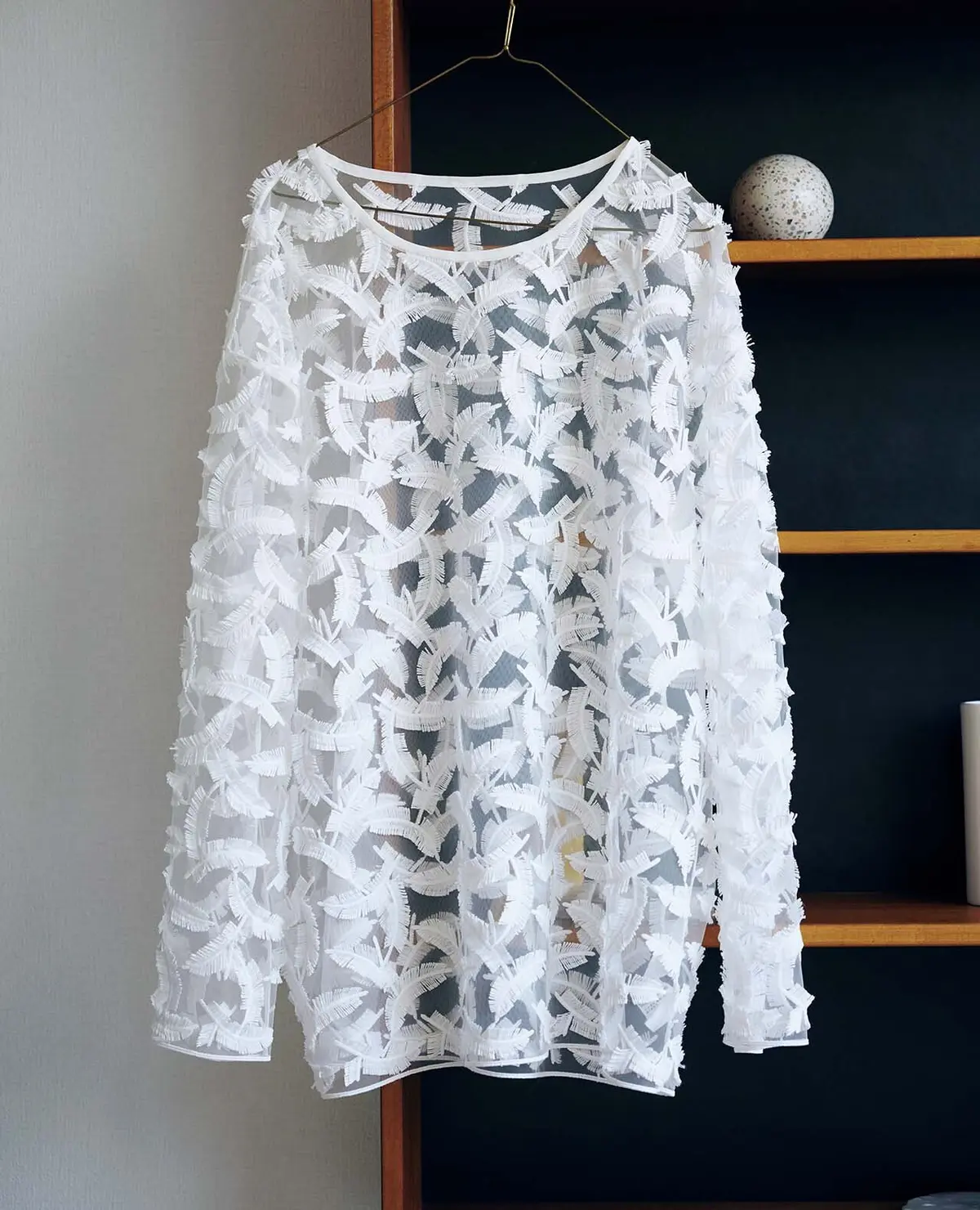 フェザーモチーフを並べたエアリーなブラウス。カットソーやシャツの上に重ねて新しいレイヤ ードスタイルを楽しんで。ブラウス￥59,400／トゥモローランド 渋谷本店（トゥモローランド ビー）