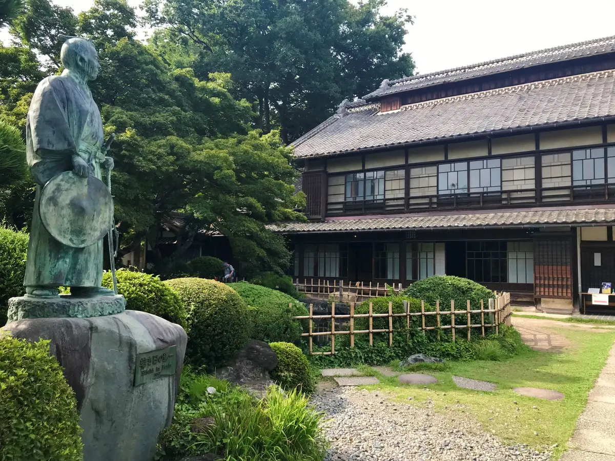 「若き日の栄一」像と主屋／中の家