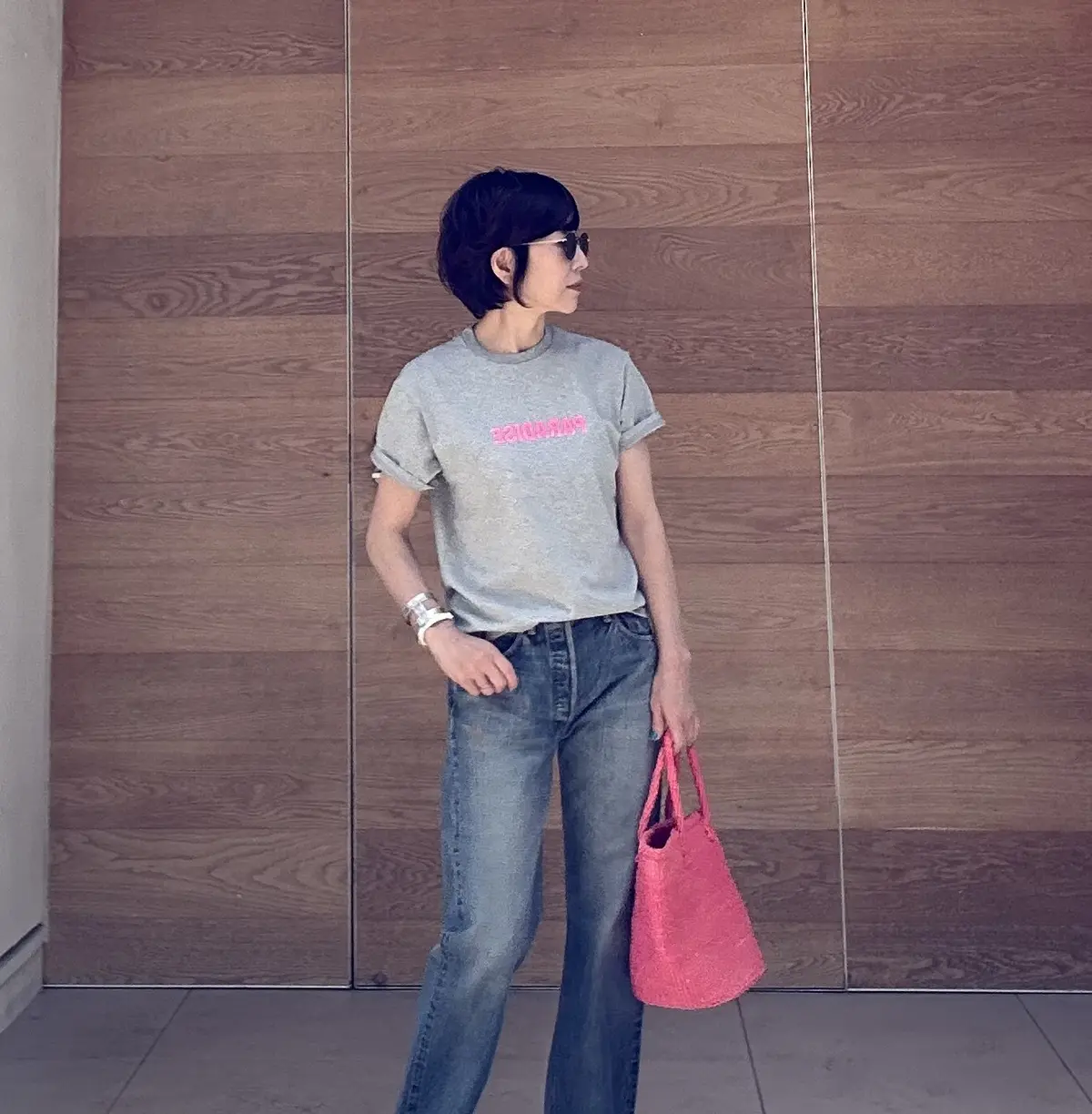 ネオンピンクのロゴTと、ピンクのサイザルカゴバッグを合わせたコーデ。
