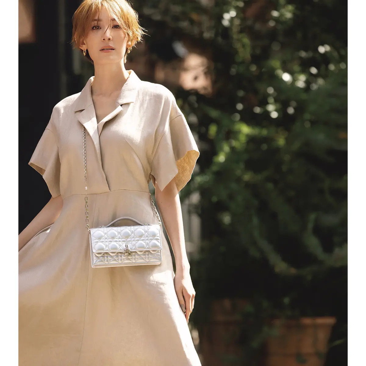 ベージュシャツワンピースにシルバーミニバッグを肩からかけた　モデル・LIZA