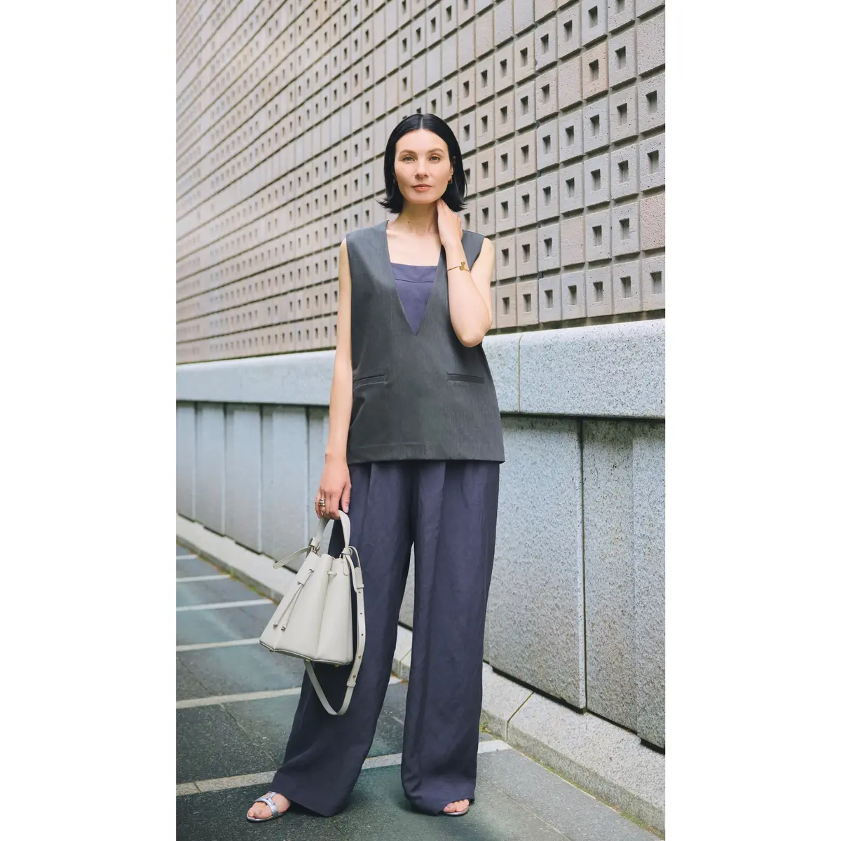 ダークブルーのオールインワンの上にグレー深Vネックトップスを重ねたコーディネート　モデル・田沢美亜