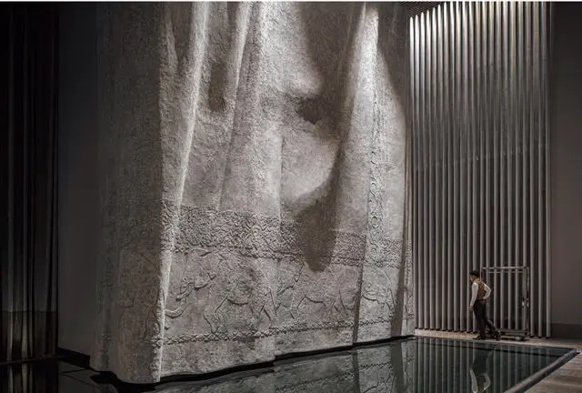 正面エントランスから入ると、8メートルもの天井高の空間に。象が描かれた布を思わせる壁状の巨大オブジェがお出迎え