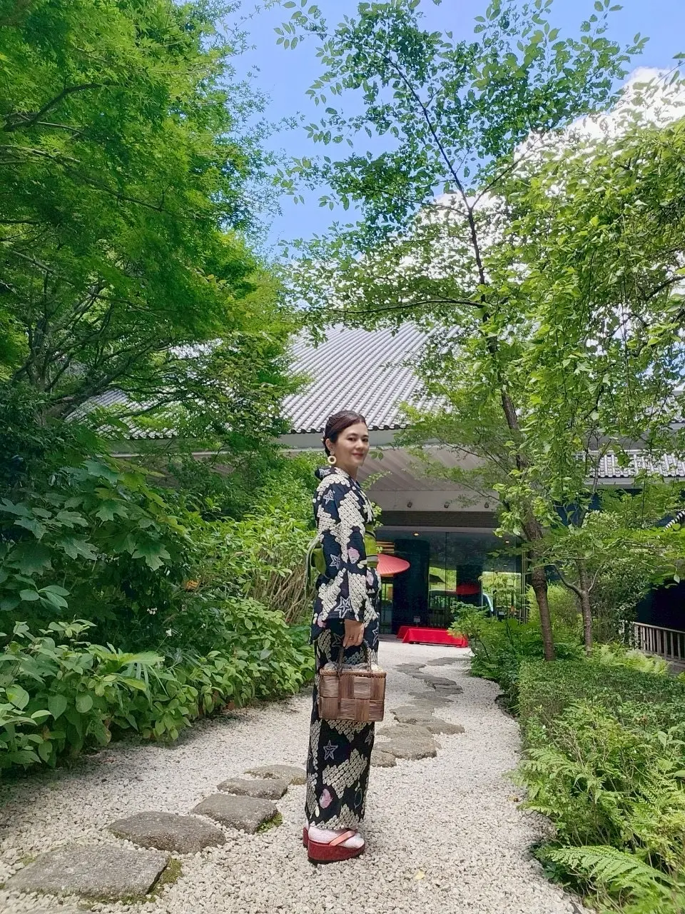 雅叙園中庭に立つ浴衣姿の女性の写真。緑とのコントラストが美しい