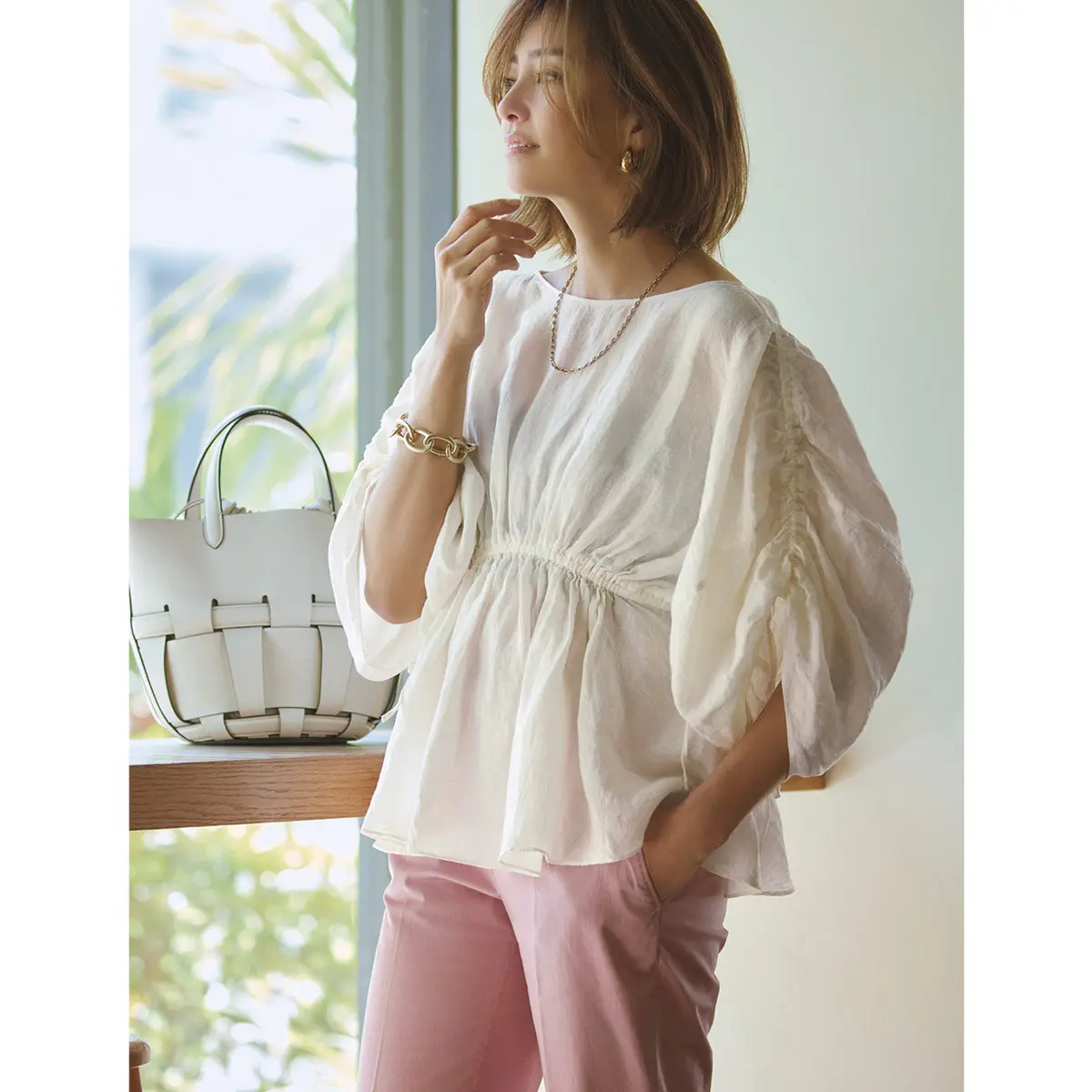 白パフスリーブトップスにピンクパンツのコーデを着たモデル・RINA