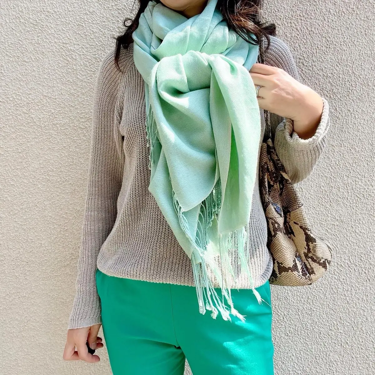 グリーンのバンツ、グレージュのニット、ライトグレーのストール、パイソン柄のバッグ