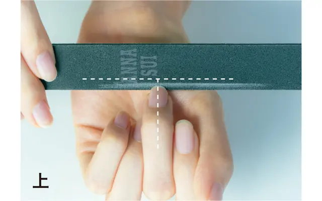 爪を爪やすりに対して垂直に、T字形に当て、削った跡がまっすぐな線になるようすべらせる。