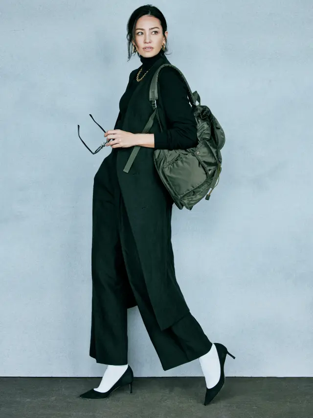 モダンな黒のワントーンには白ソックスとリュックでさりげなく抜け感を