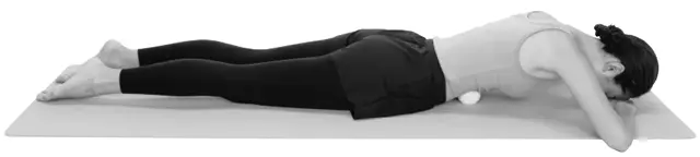 うつ伏せになり、おなかにテニスボールを当てる