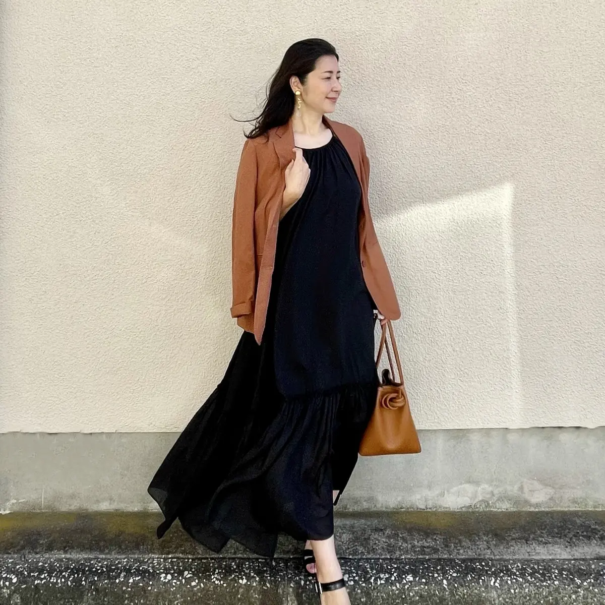 オレンジブラウンジャケット、ブラックロングワンピース、ブラックサンダル、オレンジブラウンバッグ