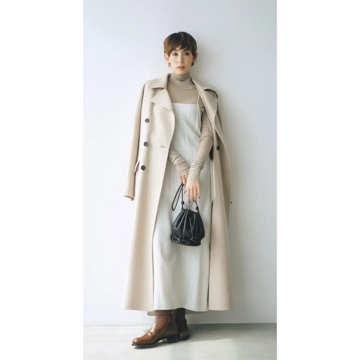 ライトベージュのロングコートとアイボリーのキャミワンピにベージュトップスのコーデ　モデル・LIZA