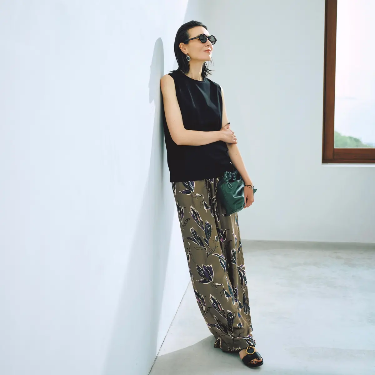 黒ノースリーブトップスにカーキ花柄ゆるパンツを合わせたコーディネート　モデル・田沢美亜