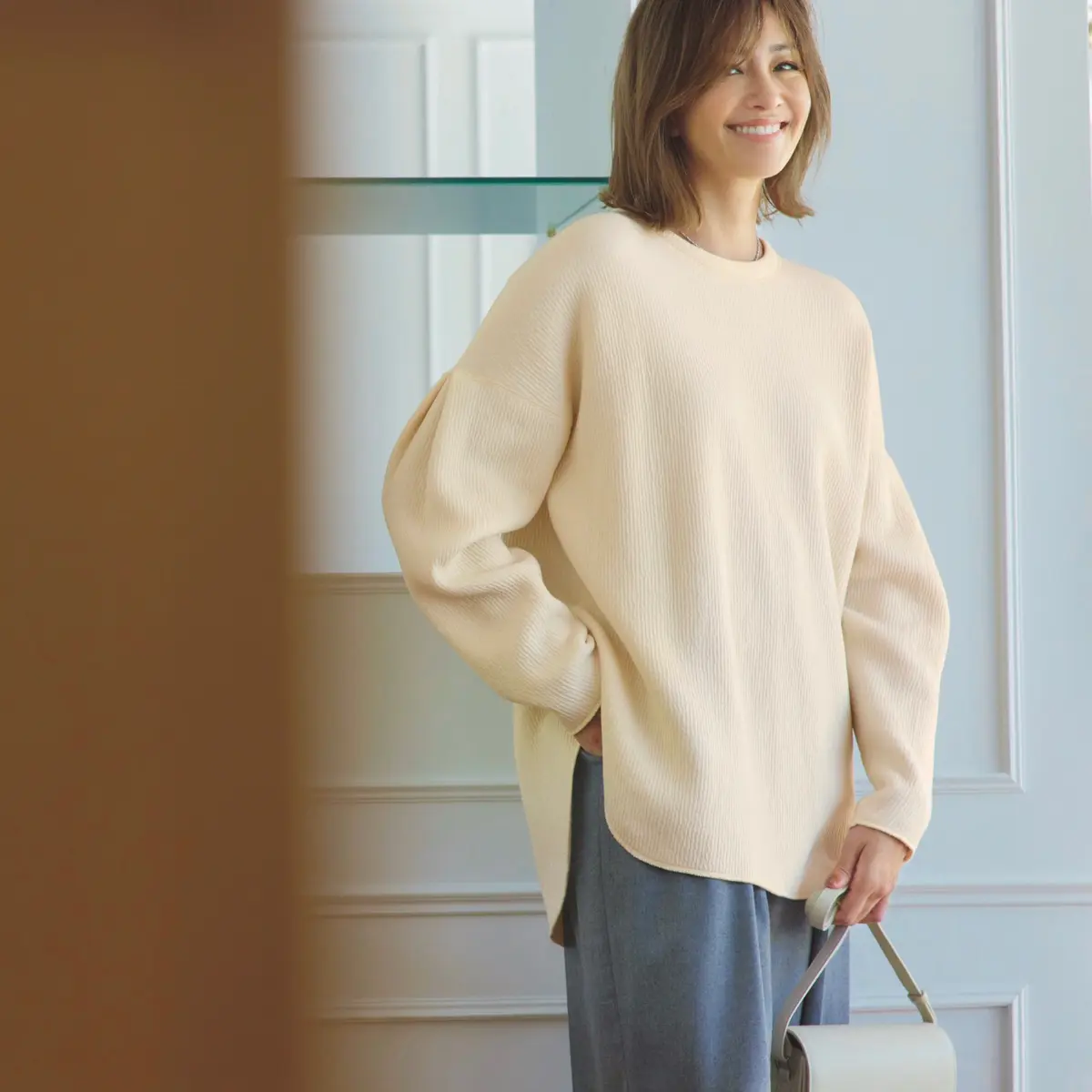 ベージュのオーバーサイズニットとグレーパンツのコーデ　モデル・RINA