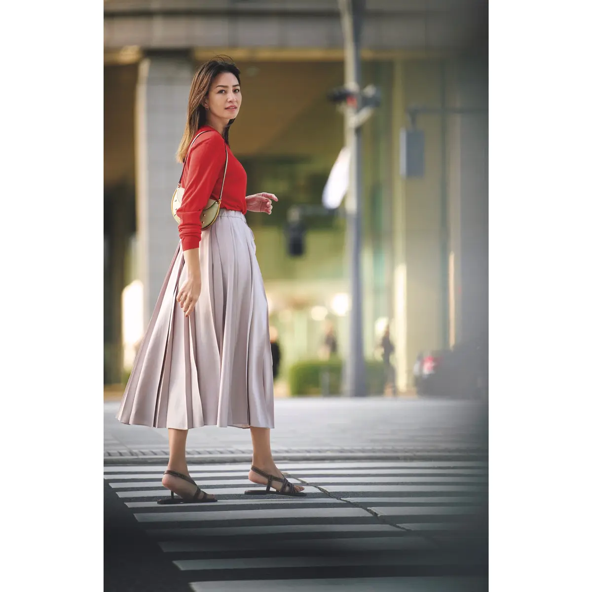 赤の長袖カットソーに薄ピンクのプリーツスカートを合わせたコーディネート　モデル・RINA