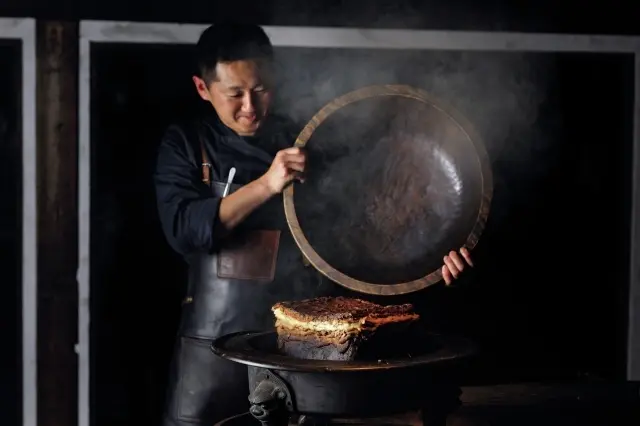 塩釜焼きをテーブルでプレゼンする小関シェフ