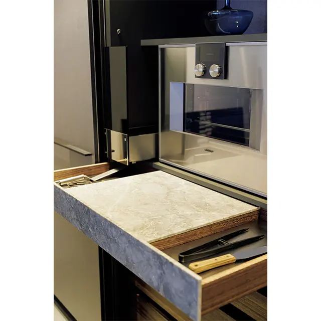 バックキャビ ネットのガゲナウのオーブンの下には熱い鍋などを置ける引き出し式の大理石の台を設置。