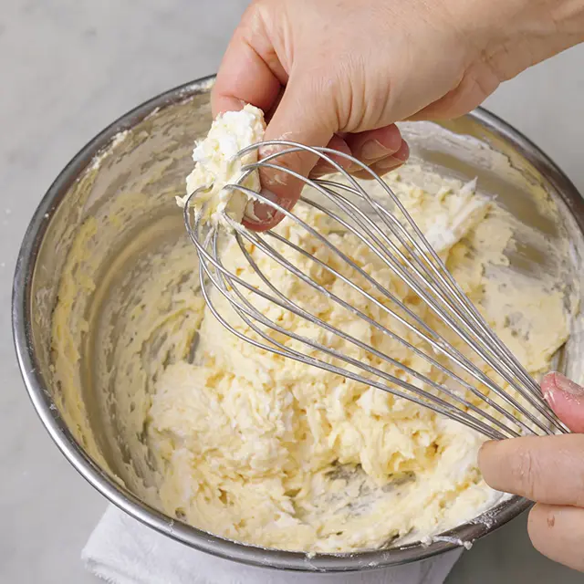 泡立て器についた生地は針金を指ではさんできれいに落とす。