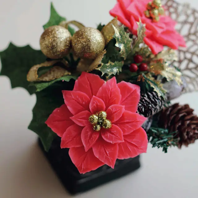 赤い石鹸を彫ったポインセチアを クリスマスアイテムと一緒に黒い器に