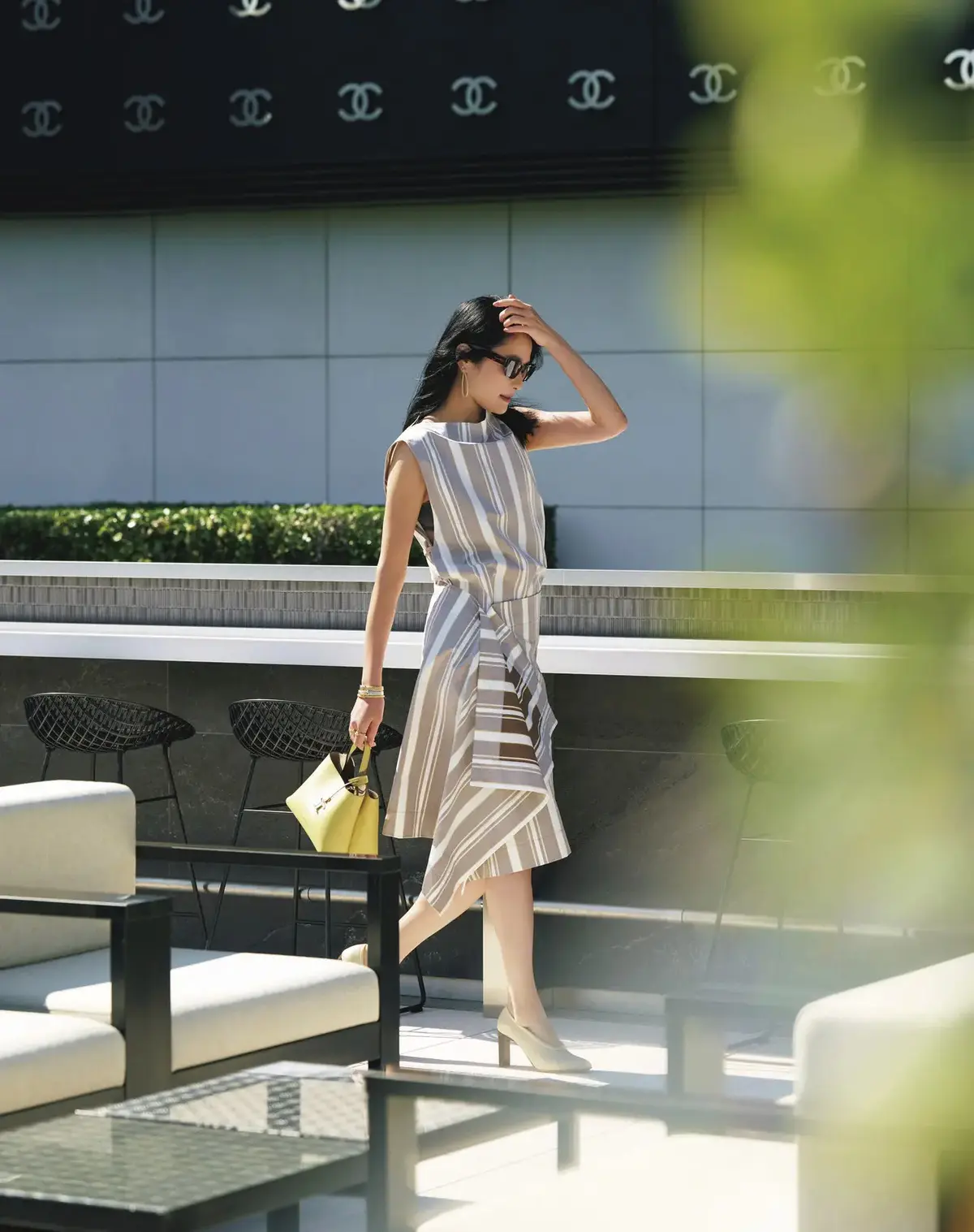 初夏の日射しに似合うマルチストライプのワンピース。張りのある素材をユニークな構造で肌見せし、ヘルシーな艶（つや）を演出。