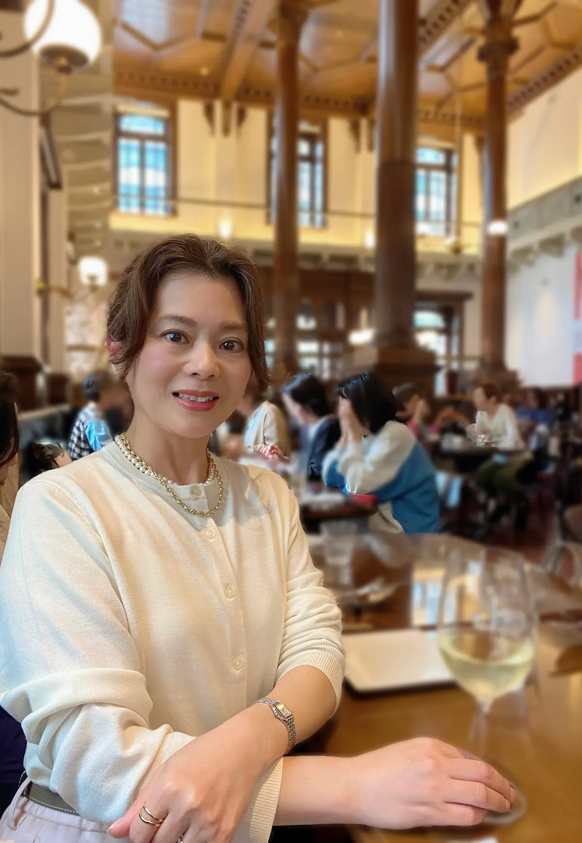 Cafe1894で白ワインのグラスに手を置いて笑う女性の画像