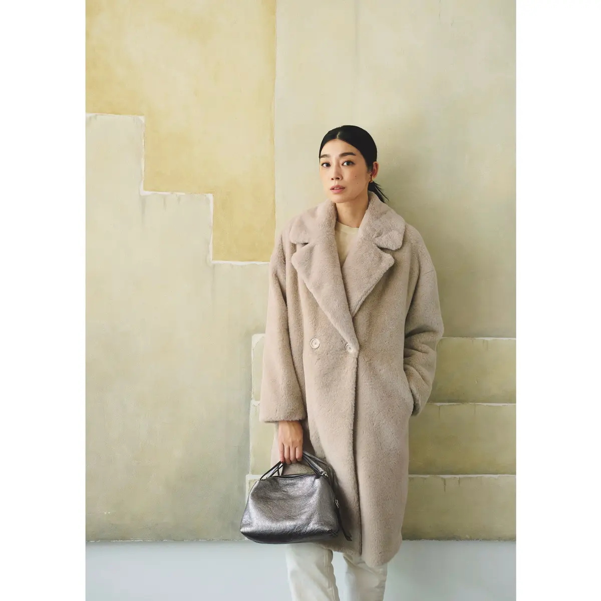 ベージュファーのロングコートにオフ白のパンツを合わせたワントーンコーデ　モデル・ゆうき