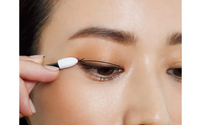 まぶたのきわに引いたこげ茶ラインをなじませるように、パレットのブラウンを重ねて。 目じりはすっと長めに入れ、切れ長アイに。