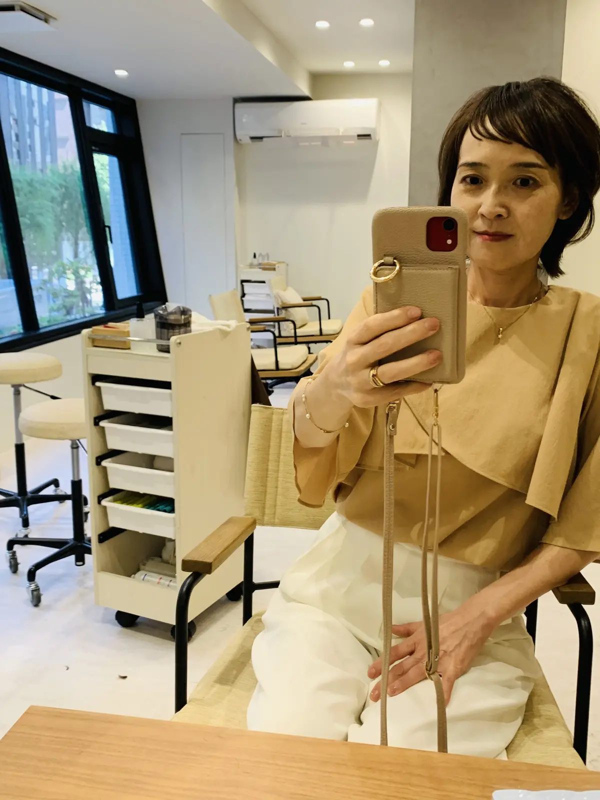 美容院でカット後、店内で写真を撮る50代女性