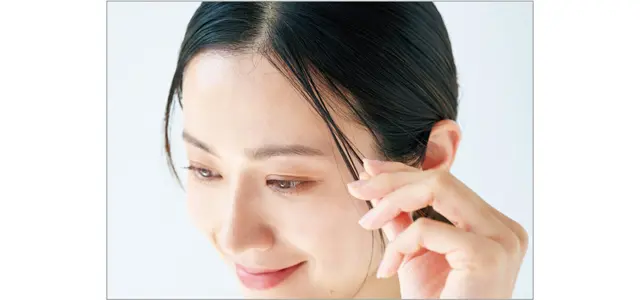 ゴムに届かないレイヤー毛束をつまみながらオイルなどを塗布。