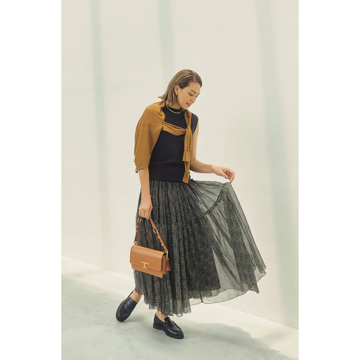 黒ノースリーブトップスとキャメルカーディガン、黒シフォンスカートのコーデを着たモデル・RINA