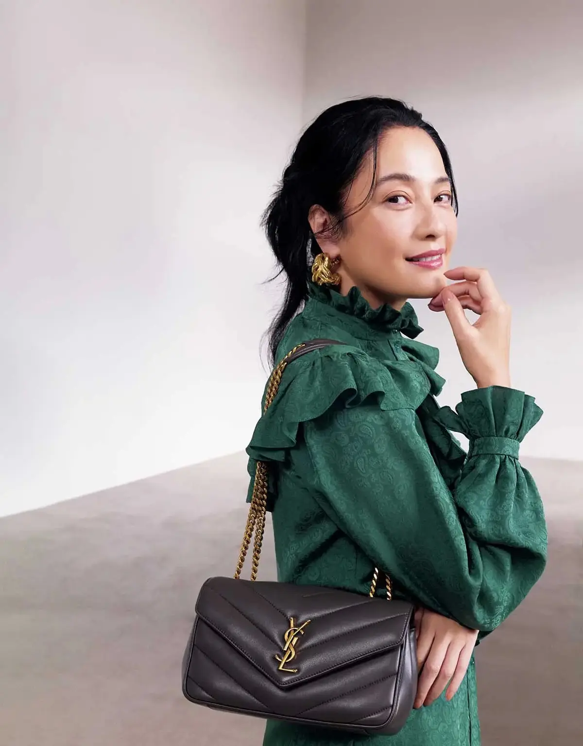 エメラルドグリーンのブラウスにグレーのチェーンバッグ。たおやかな気品が漂う色合わせ