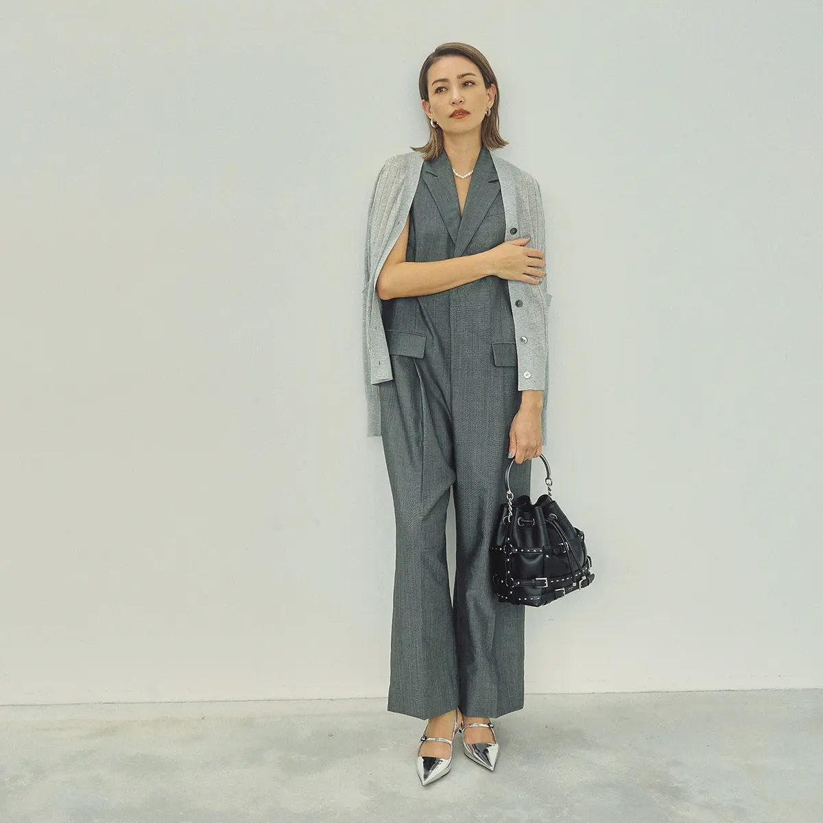 グレージャンプスーツとグレーカーデのコーデを着たモデル・RINA