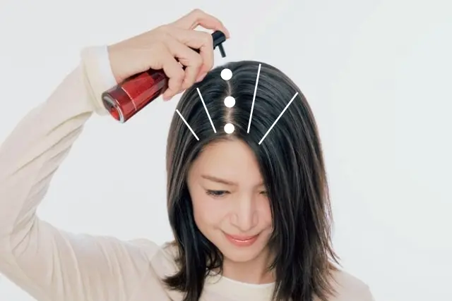 頭皮美容液の使い方のポイント：←自然にできるいつもの分け目の線上に、3カ所ほど美容液をつけたら、髪をかき分けながら頭頂部に4～5本のライン状に塗布する。