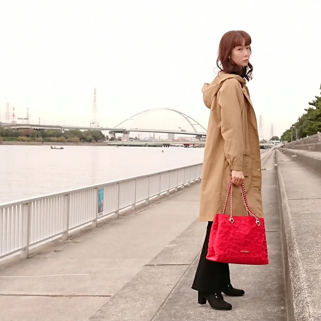 ベージュコート  赤いバッグ  黒いパンツ
