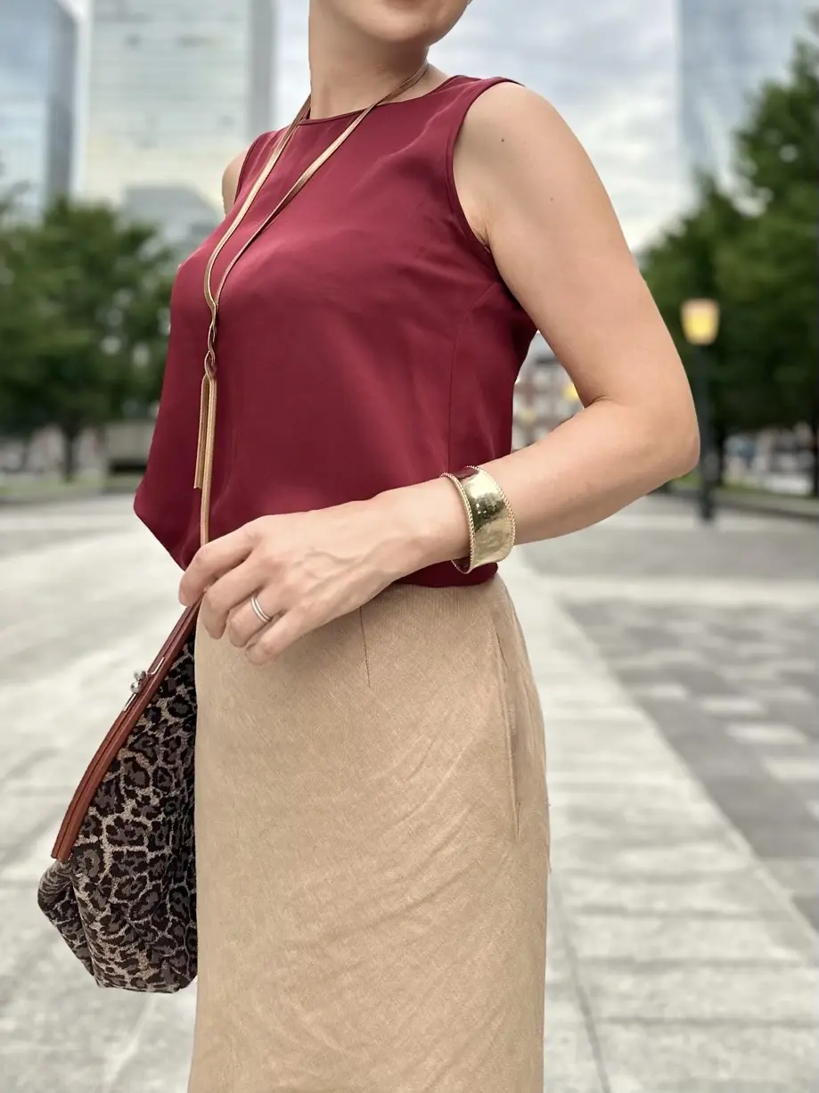 エクラプレミアムのキャメルの「リネンフレアスカート」、ボルドーのノースリーブブラウス、レオパード柄クラッチバッグ