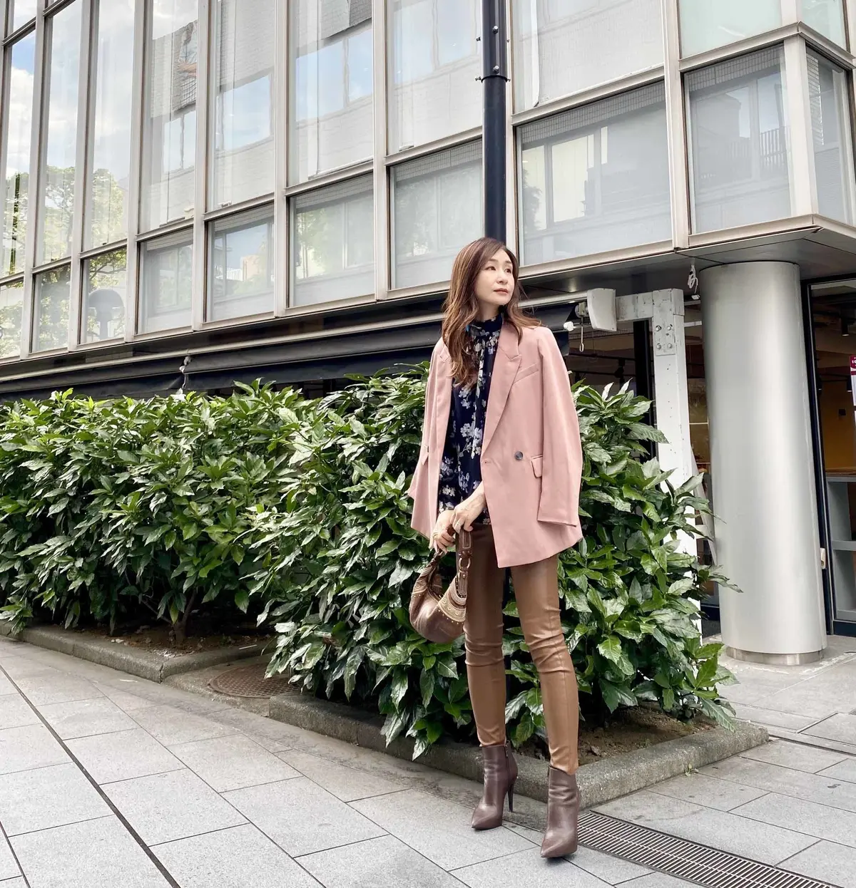 ピンクのジャケットに濃いベージュのフェイクレザーパンツ