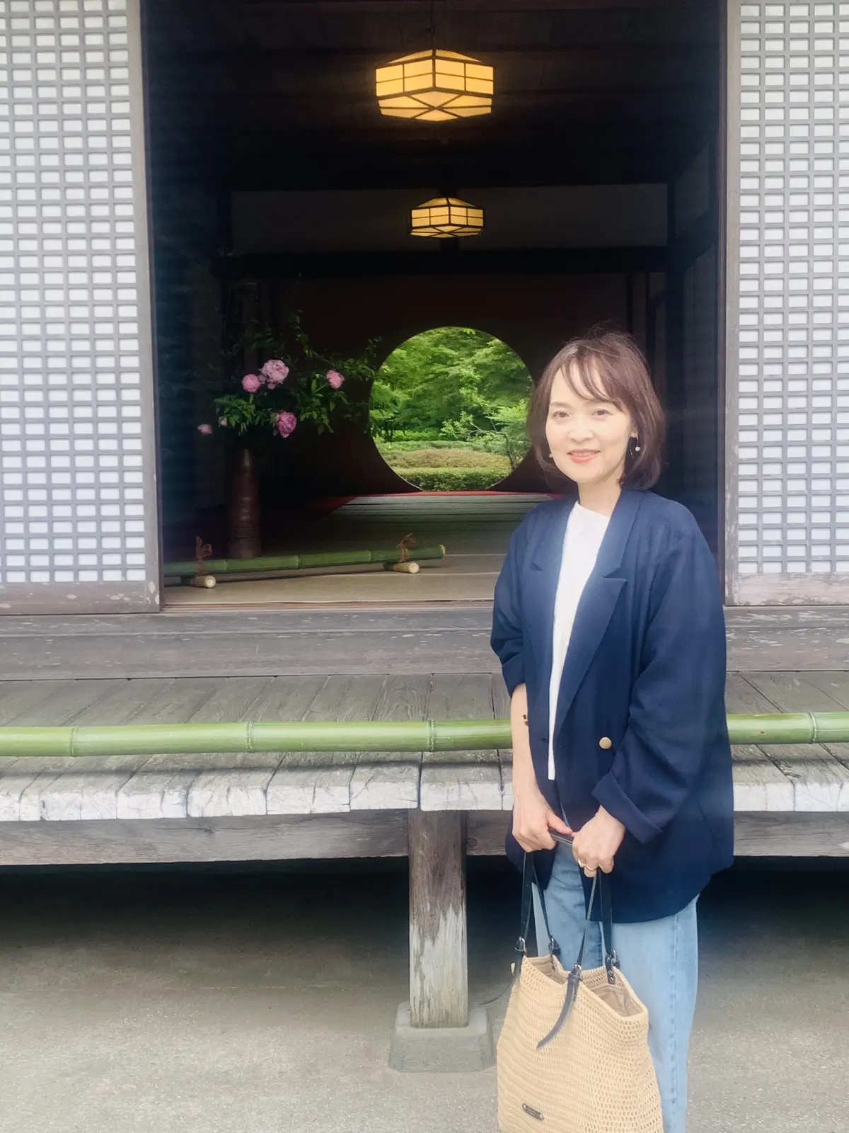 明月院の悟りの窓の前で写真撮影をする女性