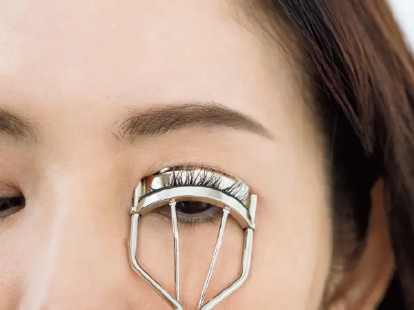 ビューラーでまつ毛のきわをはさみ上向きにカールをつける