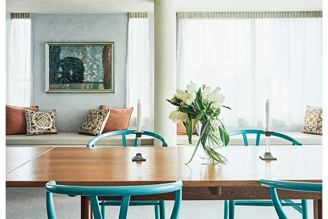 壁をイタリアンスタッコ塗りの薄いブルーグレーにし、ブルーとオレンジをさし色にして美しくまとめている。