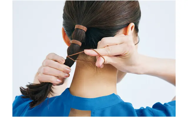 《3》約3㎝間隔で毛束に茶のゴムを巻きつける。結んだ毛束の長さに合わせ、2〜3カ所が◎。