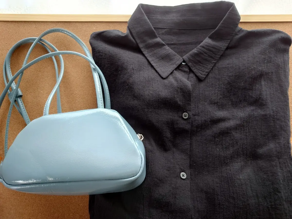 黒楊柳シャツとブルーのバッグ