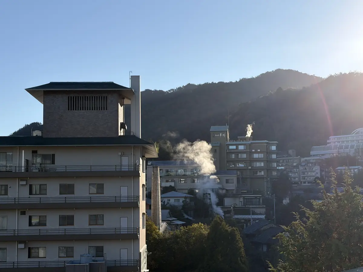 有馬温泉の泉源から湯気が立ち上り、陽光とのコントラストが美しい