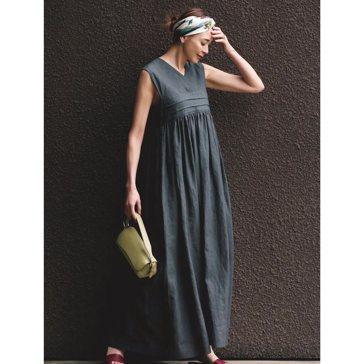 グレーノースリーブワンピースにグリーンのミニバッグとボルドーサンダルを合わせたコーディネート　モデル・SHIHO